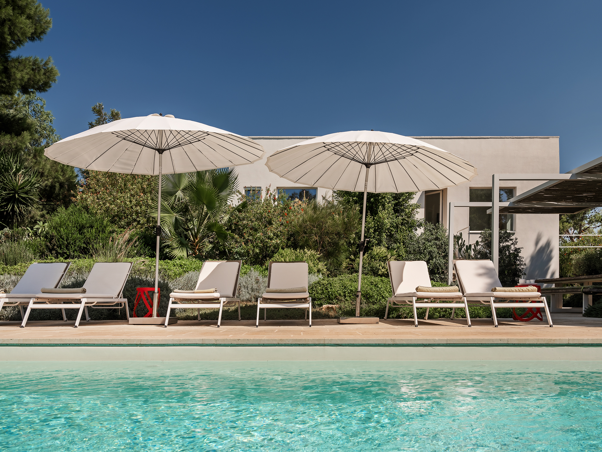 Poolbereich mit Liegen und Sonnenschirmen