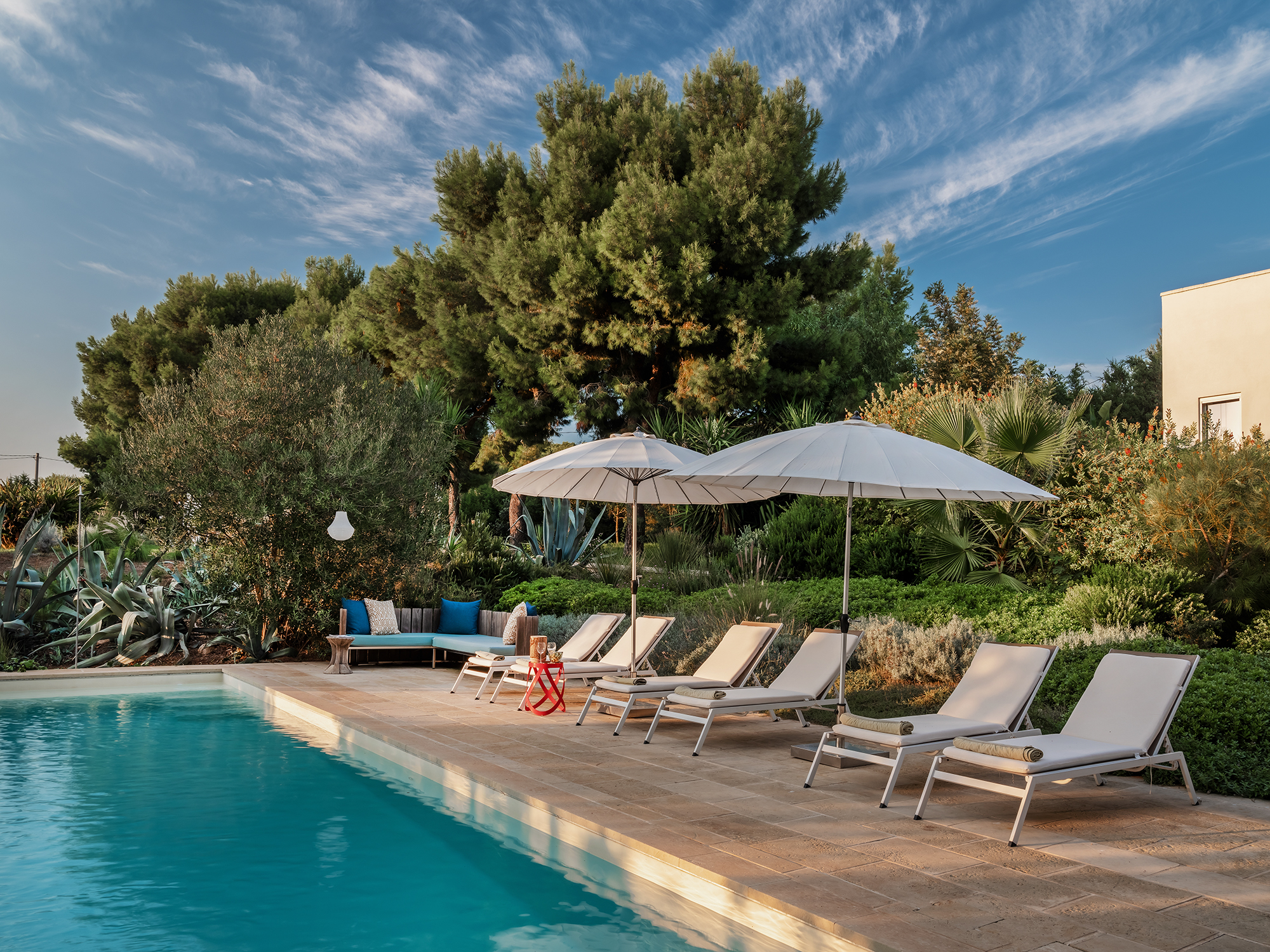 Poolbereich mit Liegen und Sonnenschirmen