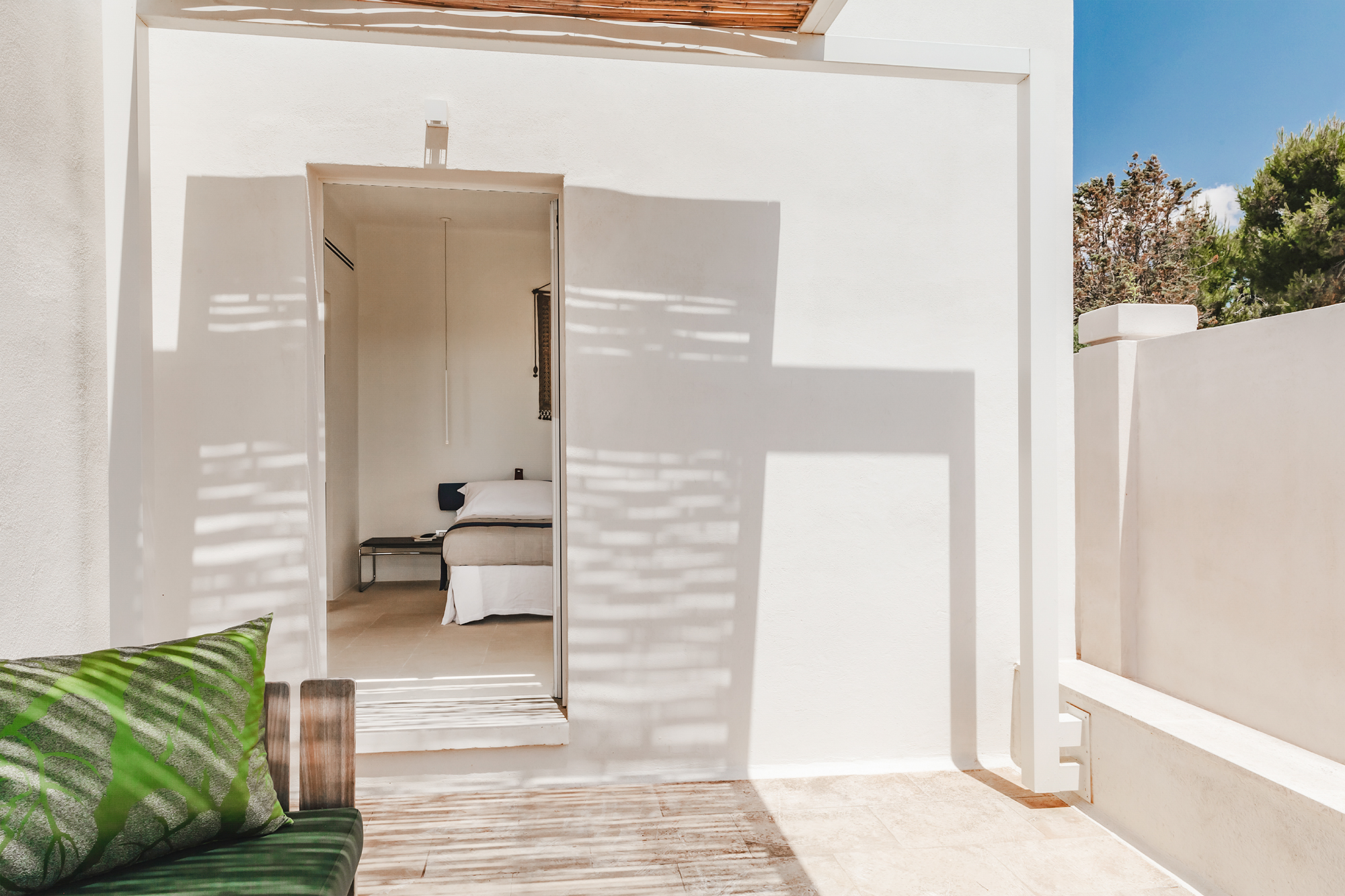 Terrasse mit Blick in ein helles Schlafzimmer