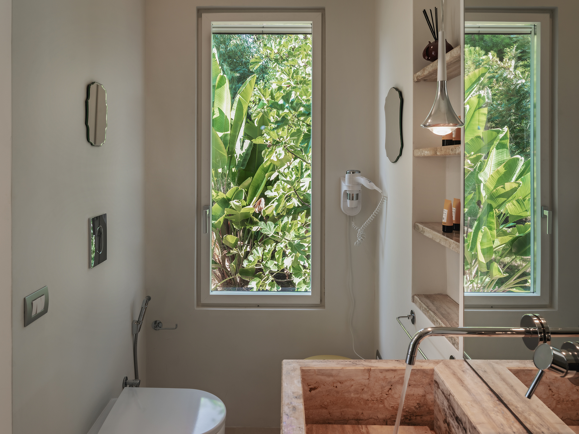 Modernes Badezimmer mit Naturstein-Waschbecken und Gartenblick