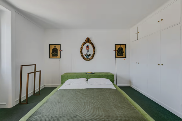 Schlichtes Schlafzimmer mit grünen Textilien und Einbauschränken