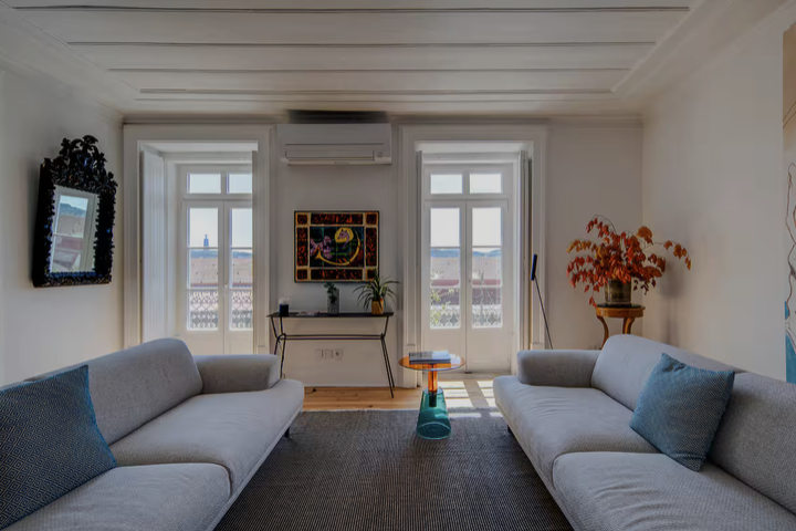 Helles Wohnzimmer mit zwei Sofas und Balkonfenstern