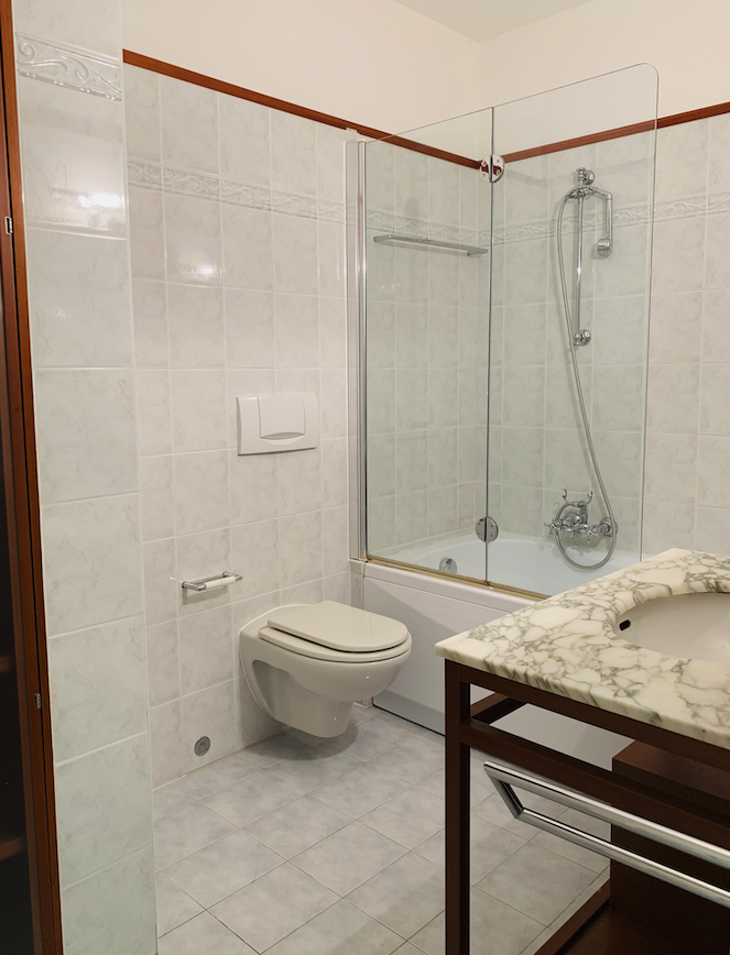 Badezimmer mit Wanne, Glasabtrennung und Wand-WC