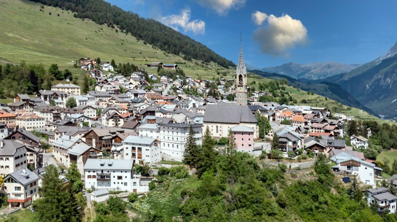 Alpenort mit Kirche und Bergpanorama