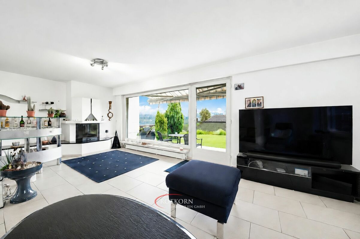 Heller Wohnraum mit großem Fenster und TV