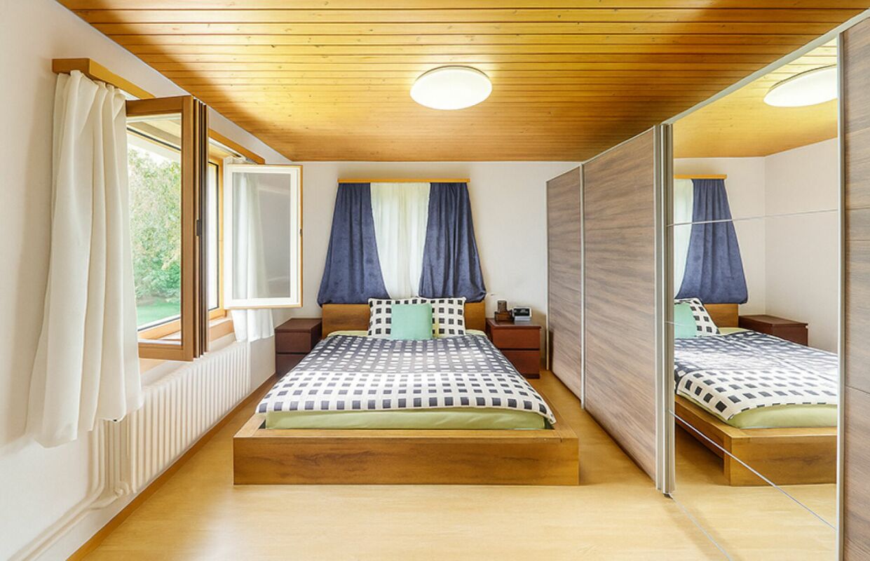 Schlafzimmer mit Holzdecke und Spiegelkleiderschrank