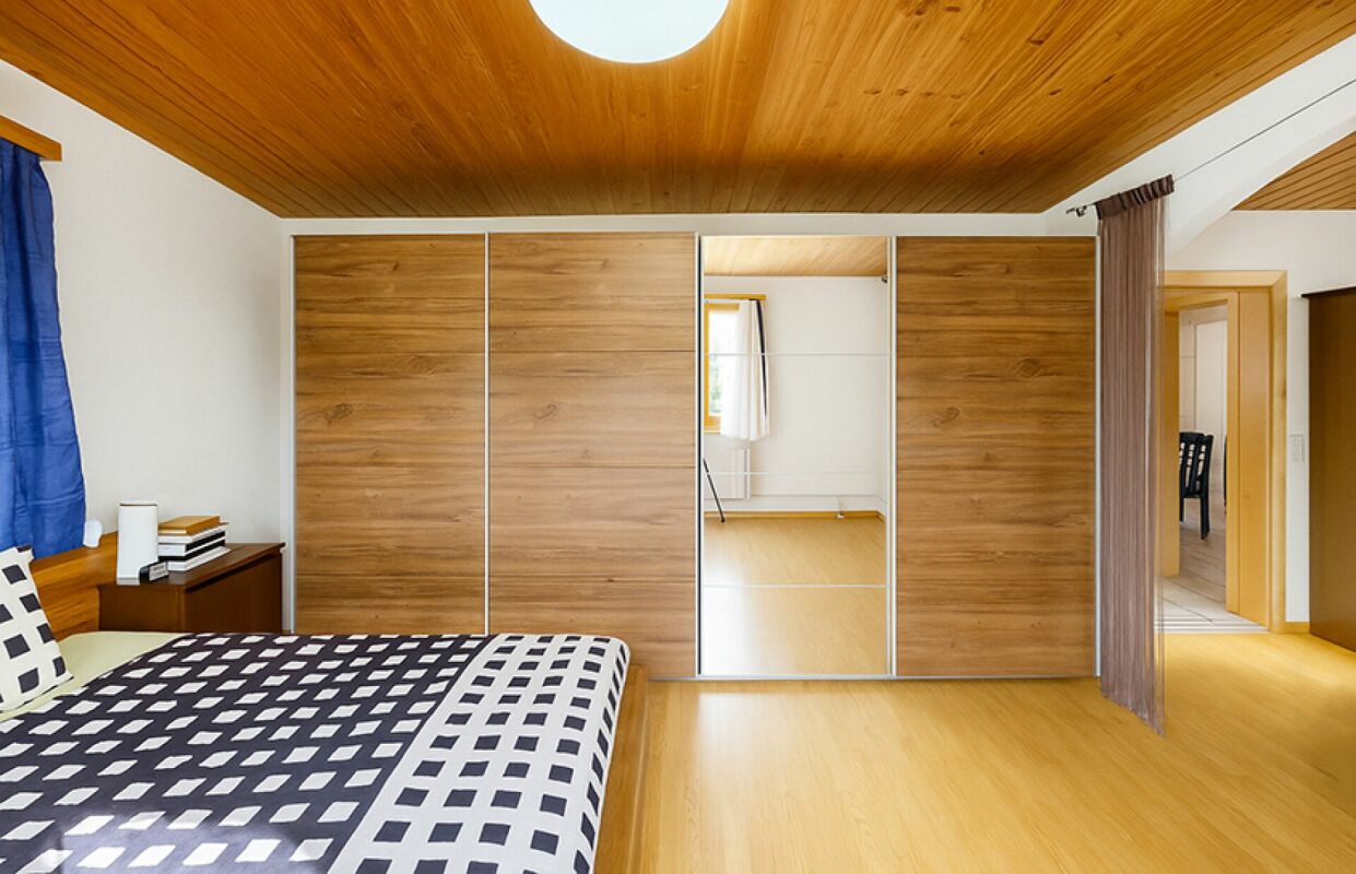 Schlafzimmer mit Holzdecke und Einbauschrank