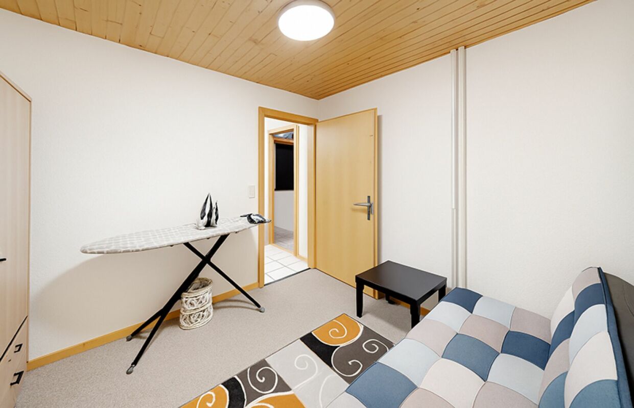 Helles Schlafzimmer mit Holzdecke und Sofa