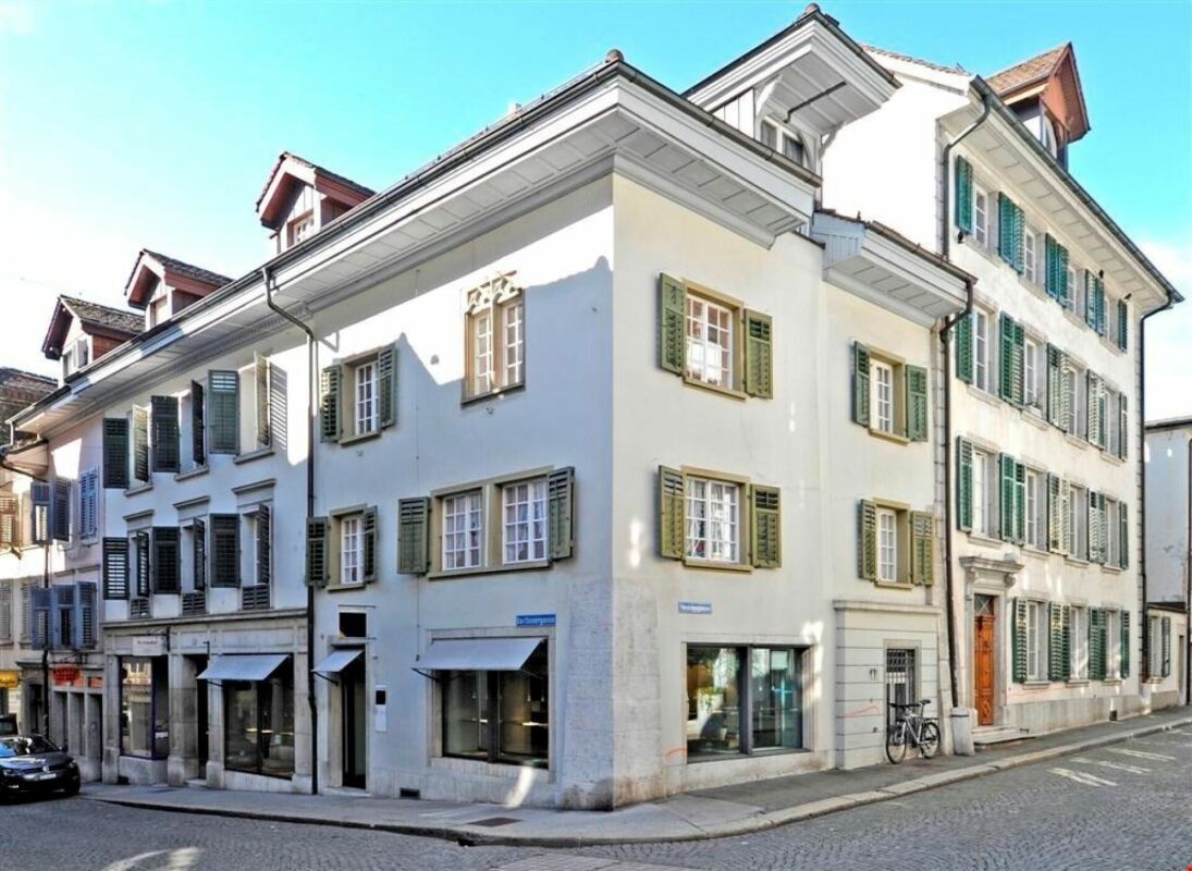 Historisches Eckgebäude an einer Kopfsteinpflasterstraße