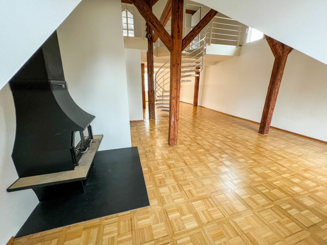 Großer Wohnraum mit Kamin und offener Treppe