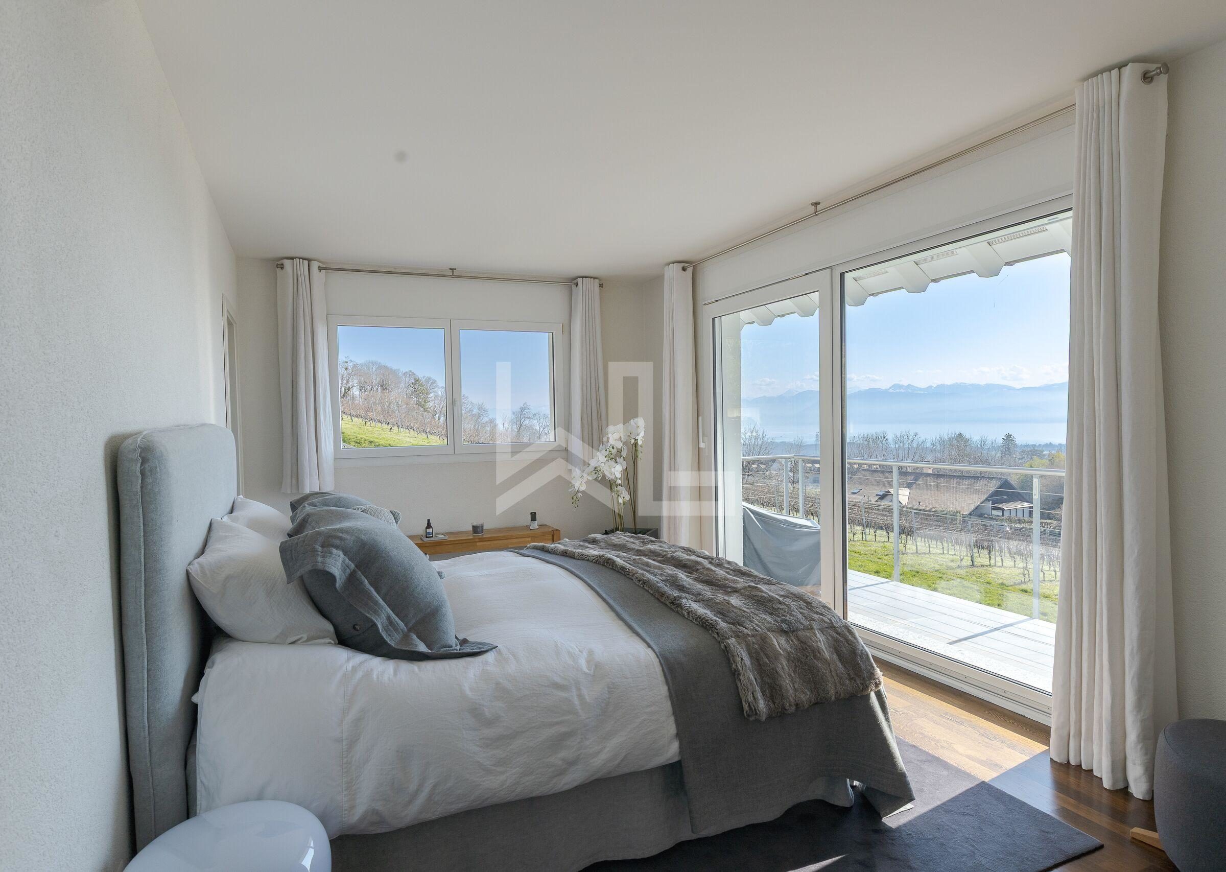 Helles Schlafzimmer mit Balkon- und Seeblick