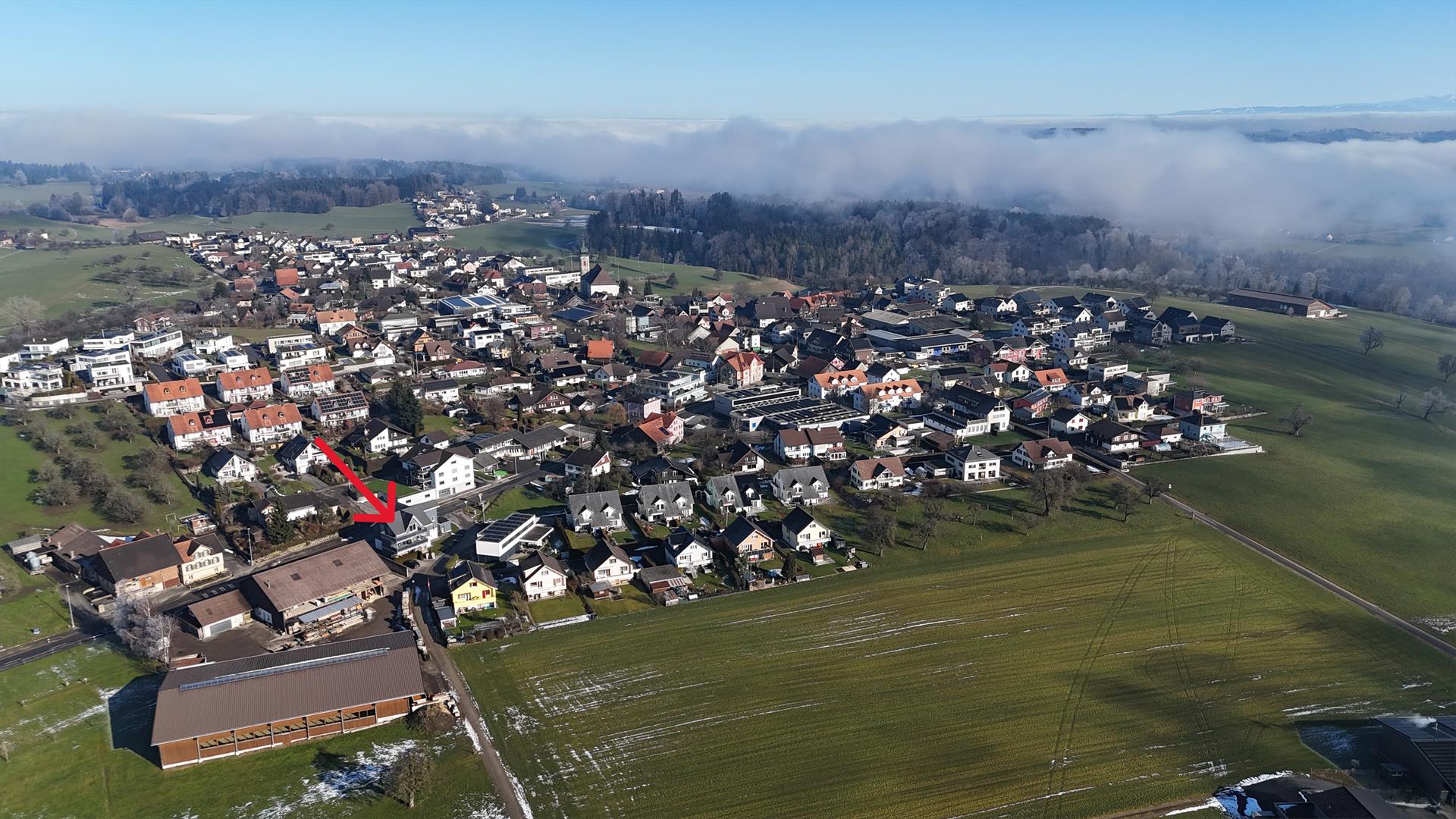 Luftaufnahme eines Dorfes mit umliegenden Feldern