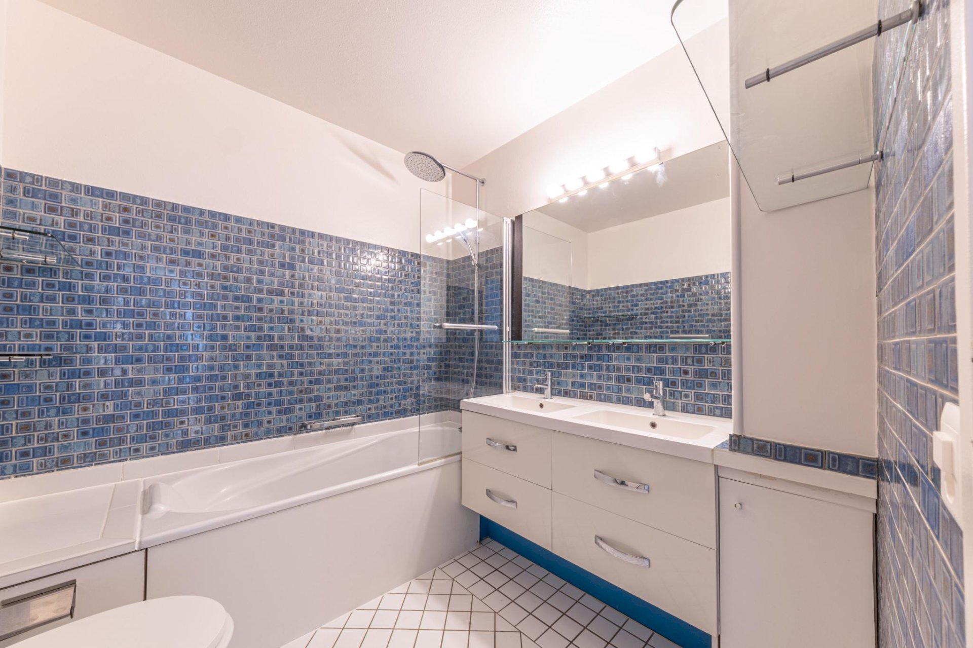 Modernes Badezimmer mit blauen Mosaikfliesen und Badewanne