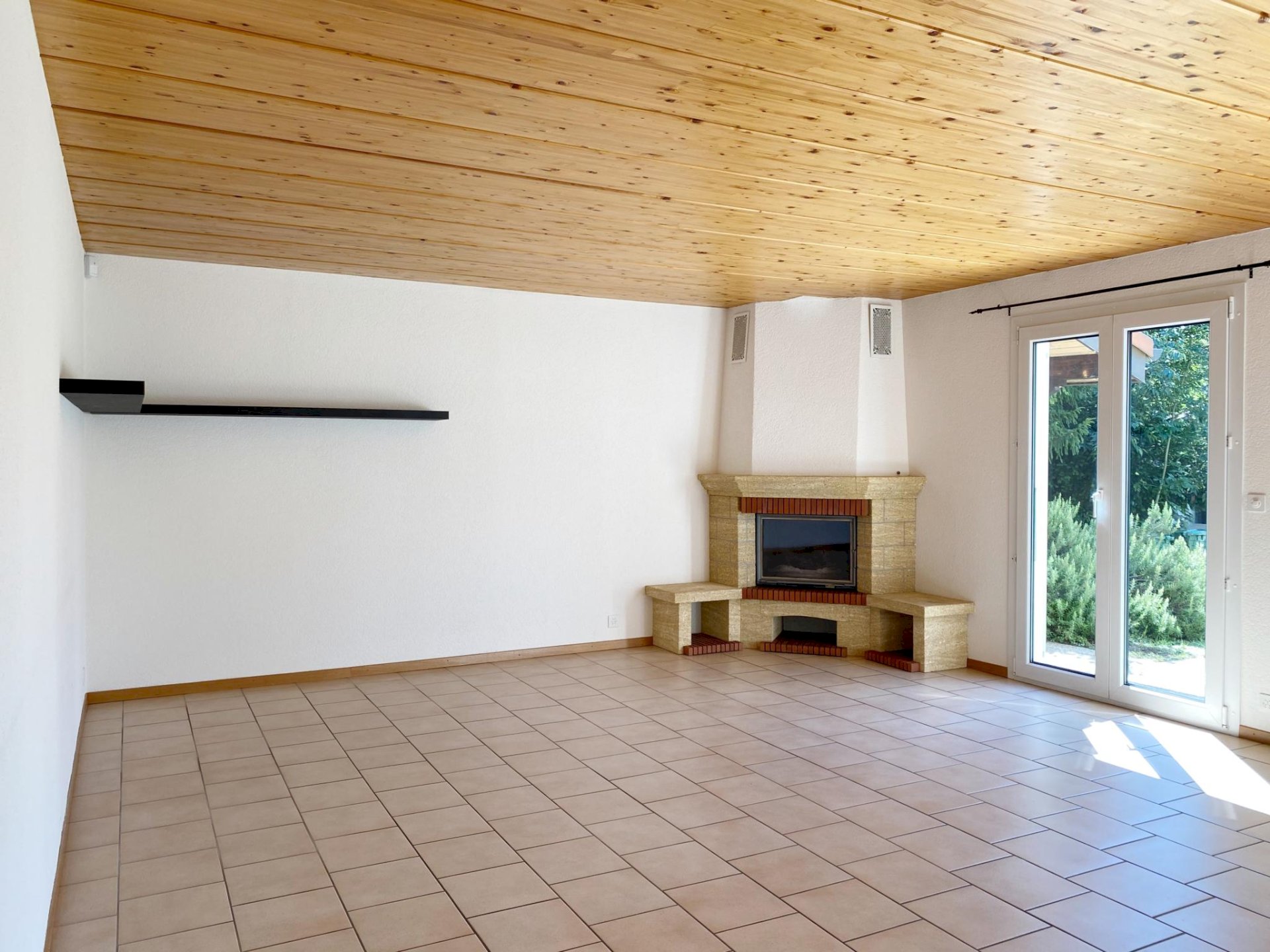 Heller Wohnraum mit Kamin und Terrassentür