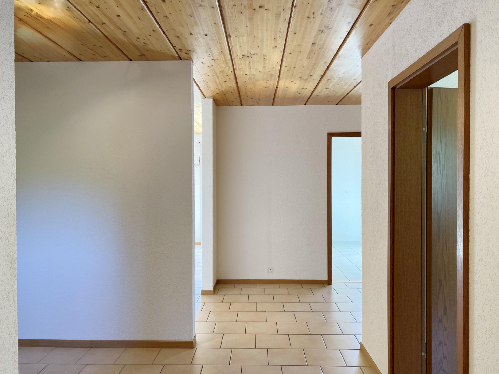 Heller Flur mit Holzdecke und Fliesenboden