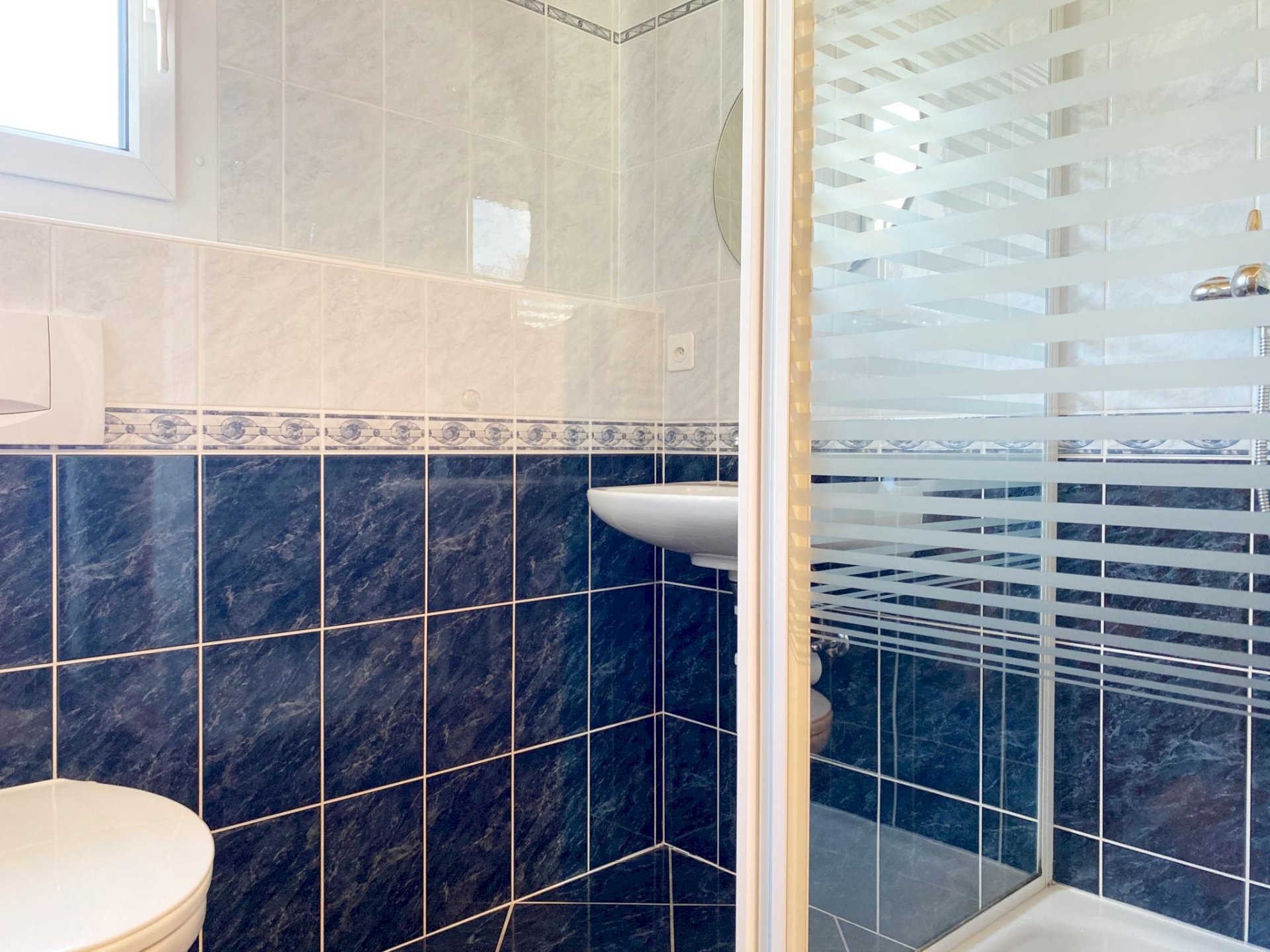 Kleines Badezimmer mit blau-weißen Fliesen