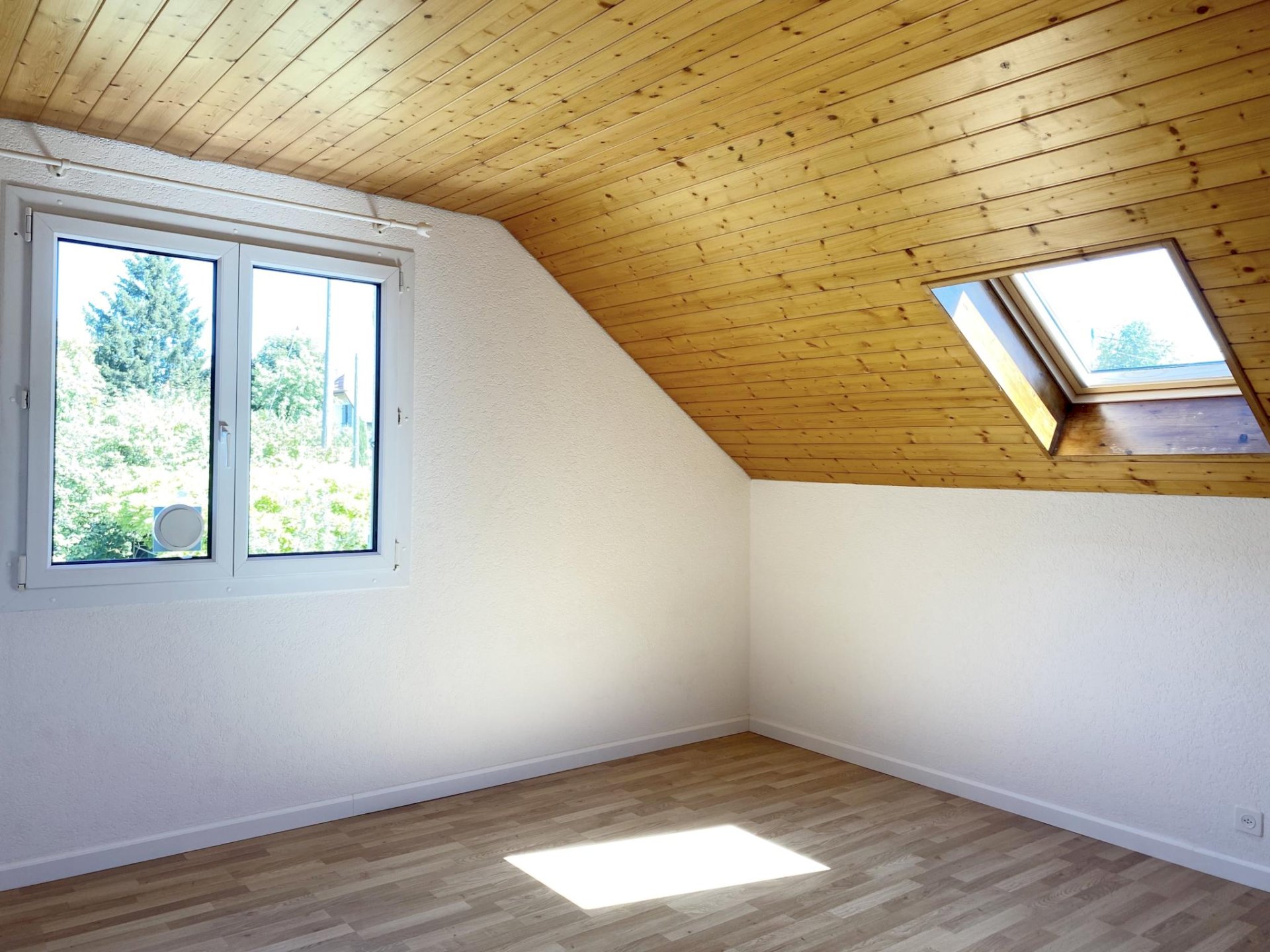Dachzimmer mit Dachfenster und Holzdecke