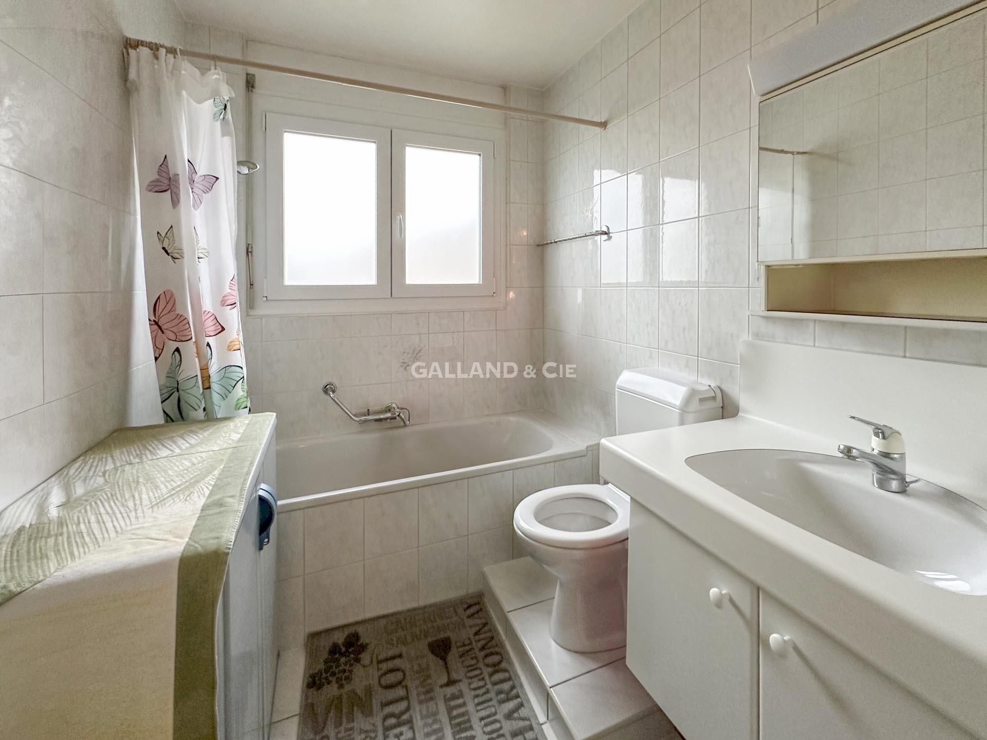 Helles Badezimmer mit Badewanne, Waschtisch und Toilette