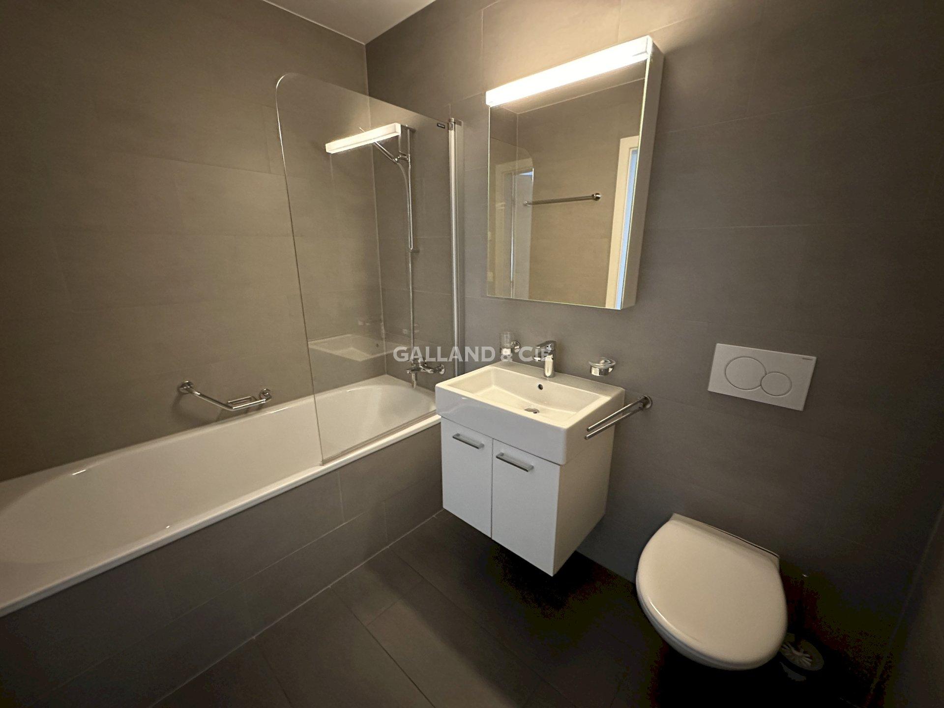 Modernes Badezimmer mit Badewanne und Wand-WC