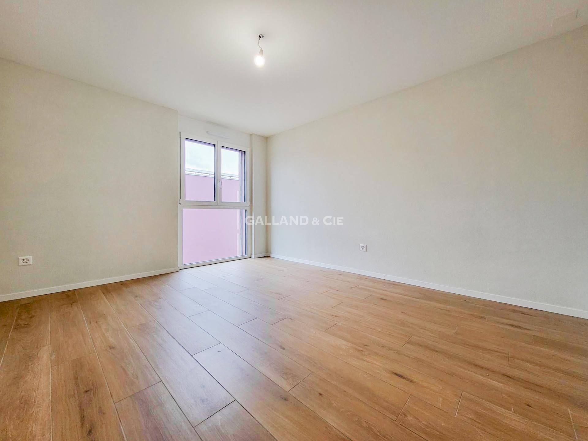 Leerer, heller Raum mit Holzboden und Fenster