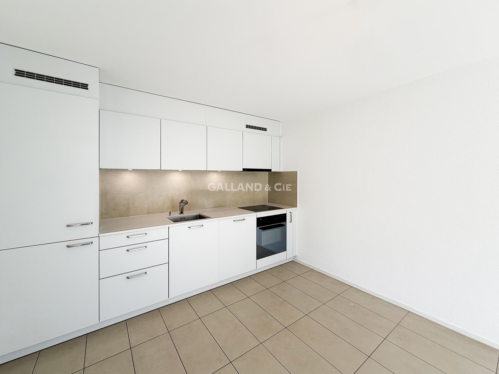 Moderne weiße Küche mit beigem Fliesenspiegel