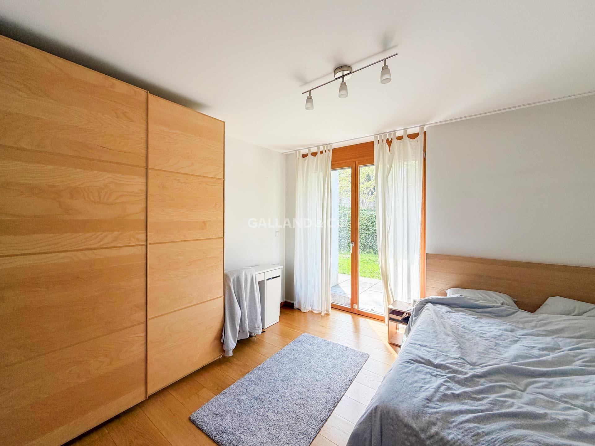 Helles Schlafzimmer mit Holzschrank und Terrassentür