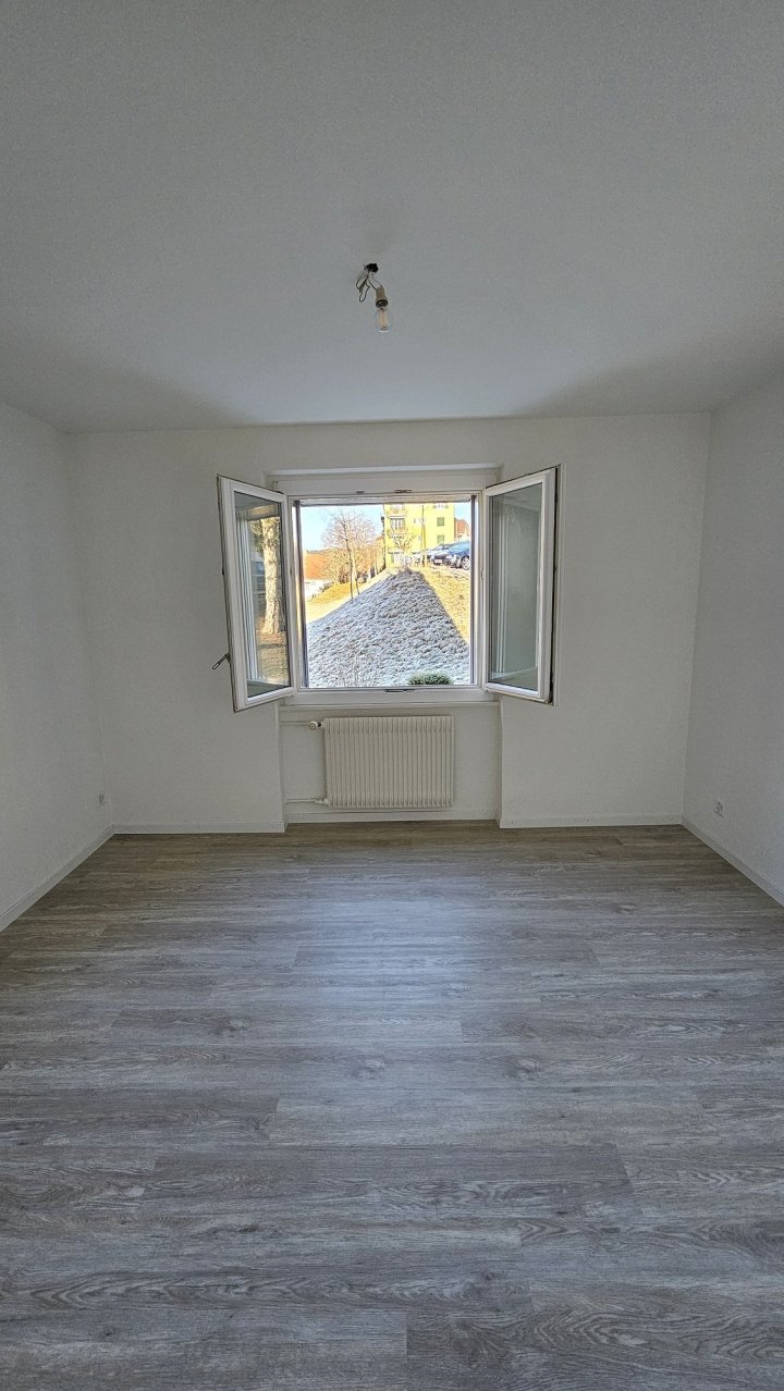Leerer Wohnraum mit Fenster und Heizkörper