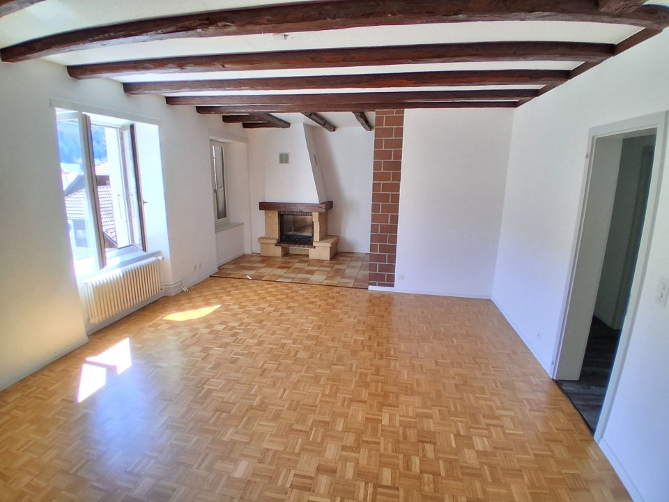 Wohnzimmer mit Kamin und Holzbalkendecke
