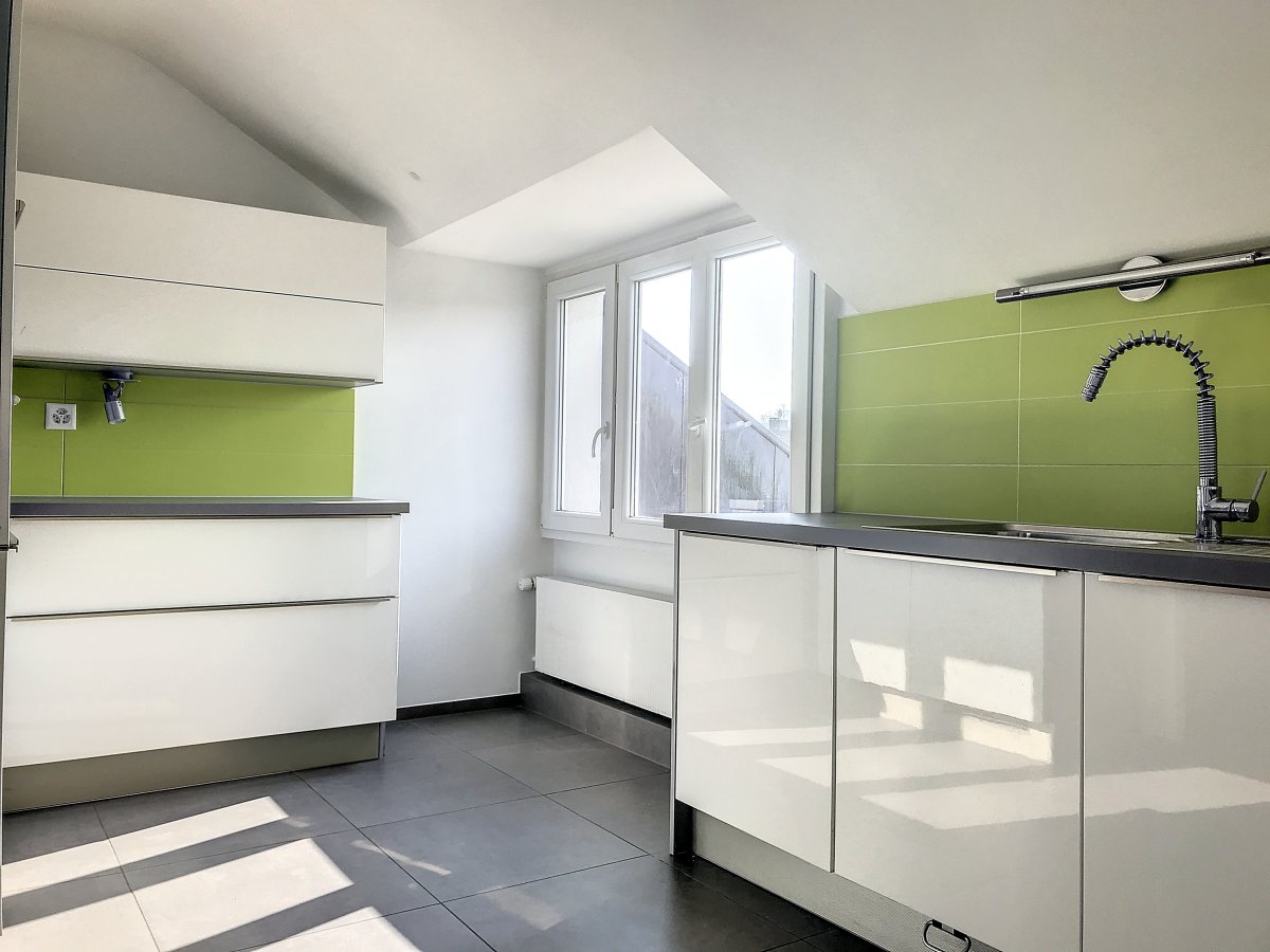 Moderne Küche mit grünen Wandfliesen und Dachfenster