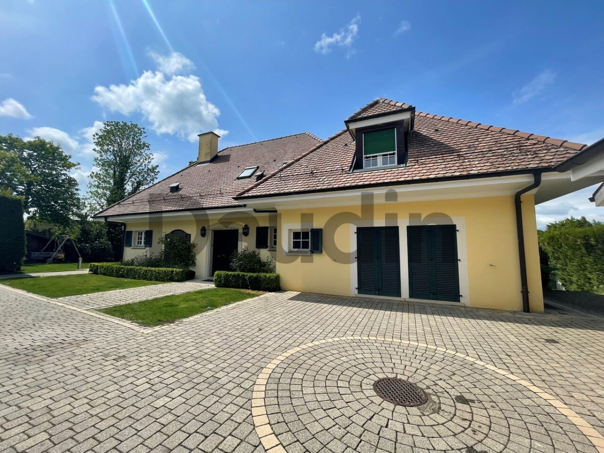 Einfamilienhaus mit Ziegeldach und großer gepflasterter Auffahrt