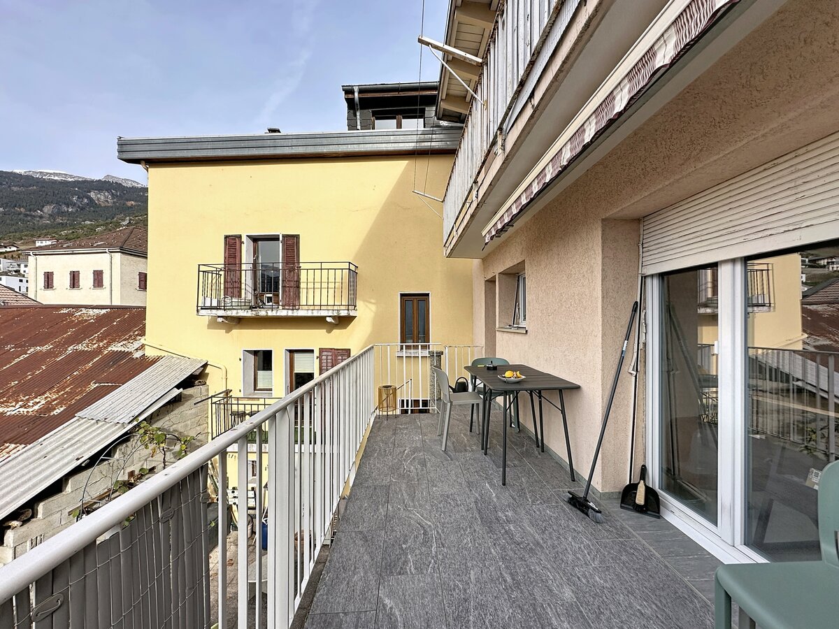 Balkon mit Blick auf Wohnhäuser und Berge