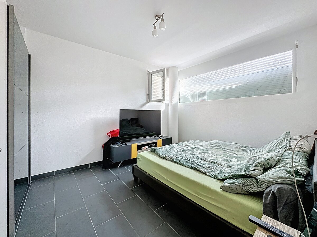 Helles Schlafzimmer mit dunklem Fliesenboden