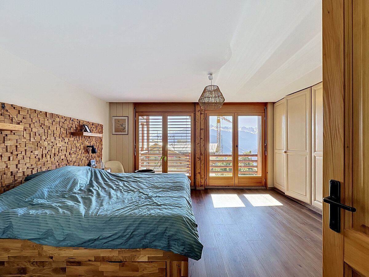 Gemütliches Schlafzimmer mit Holzakzenten und Bergblick