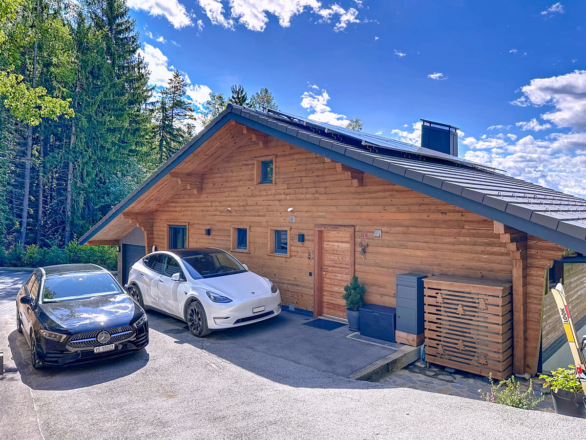 Holzchalet mit geparkten Elektroautos