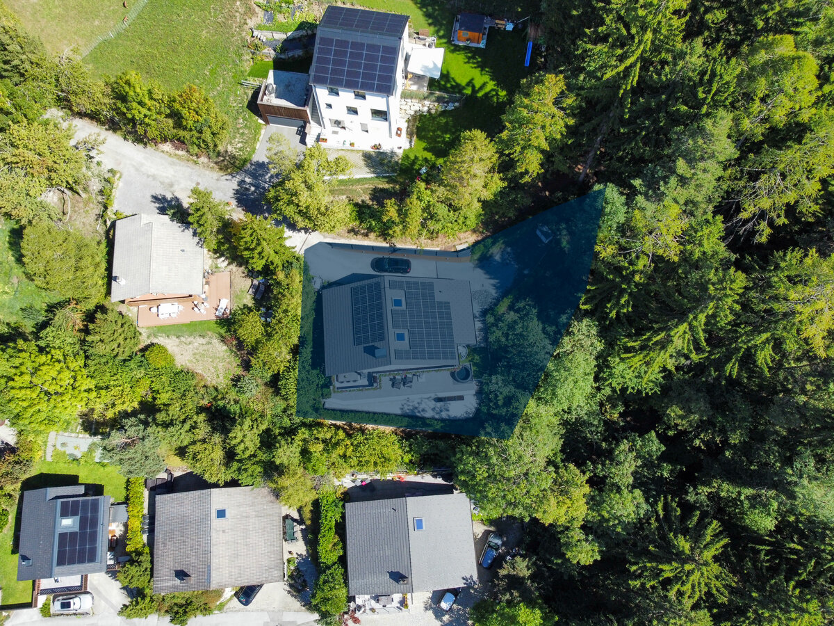 Luftaufnahme eines Hauses mit Solardach in grüner Umgebung