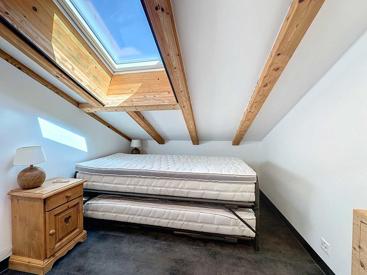 Dachgeschoss-Schlafzimmer mit Dachfenster und Holzbalken