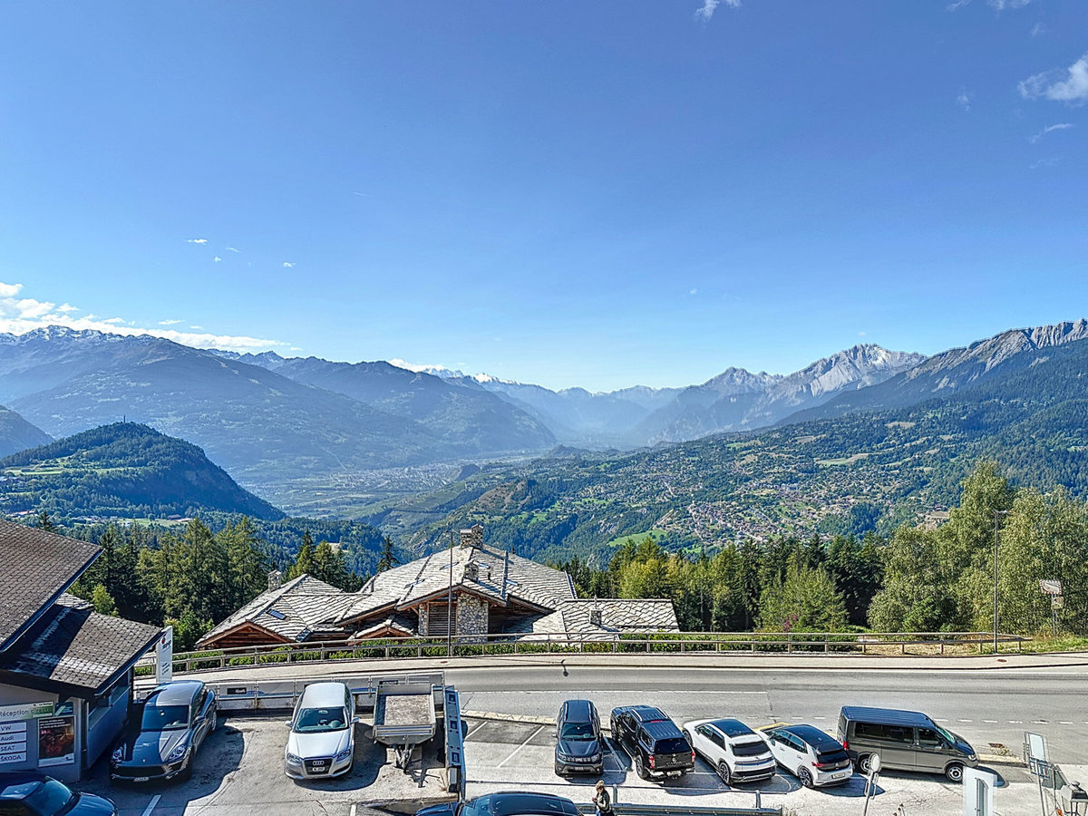 Alpenpanorama mit Straße und Parkplätzen