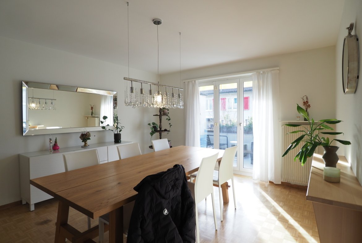Heller Essbereich mit Holztisch und Zugang zum Balkon
