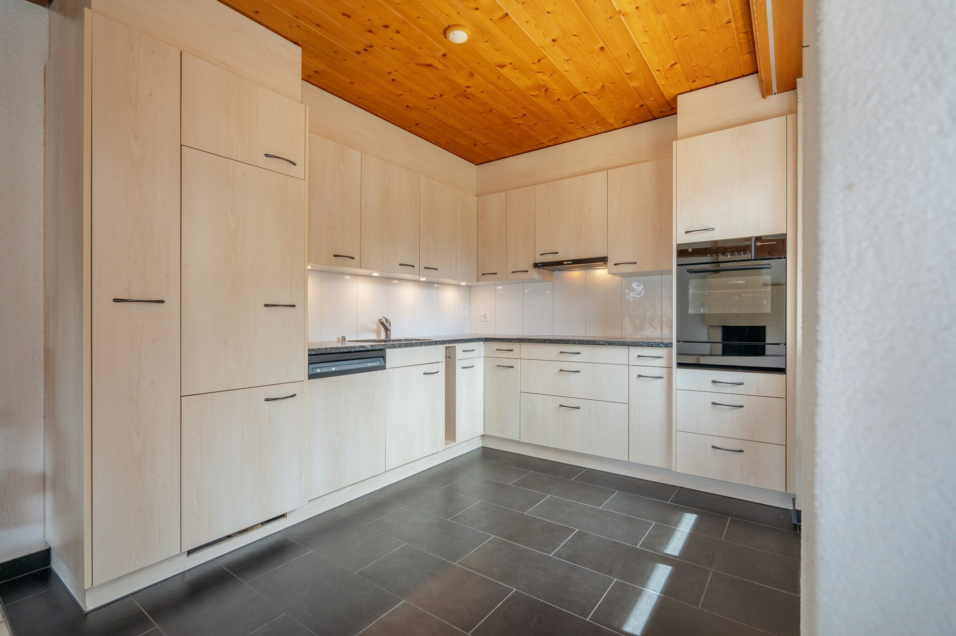 Moderne Einbauküche mit Holzdecke