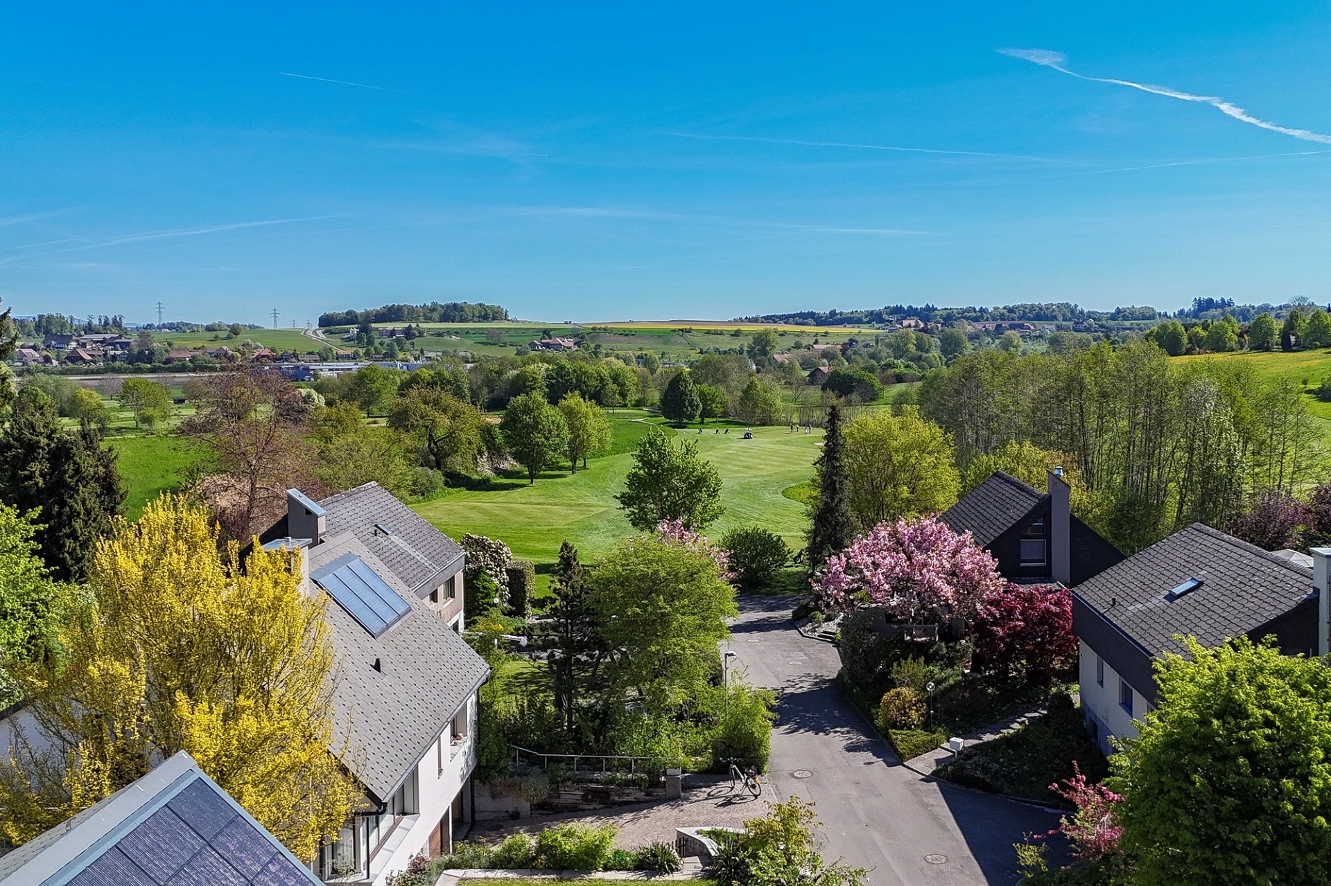 Luftaufnahme eines grünen Wohngebiets mit weitem Landschaftsblick