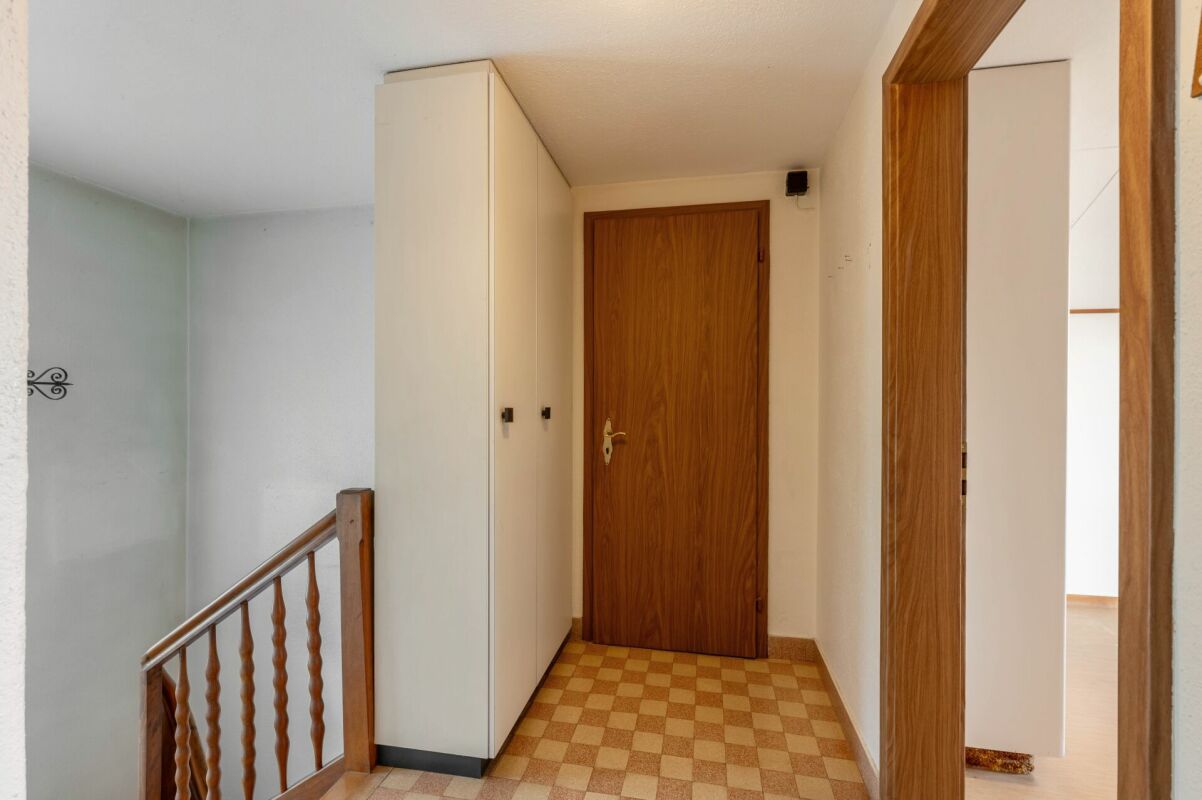 Flur mit Treppenaufgang und Einbauschrank