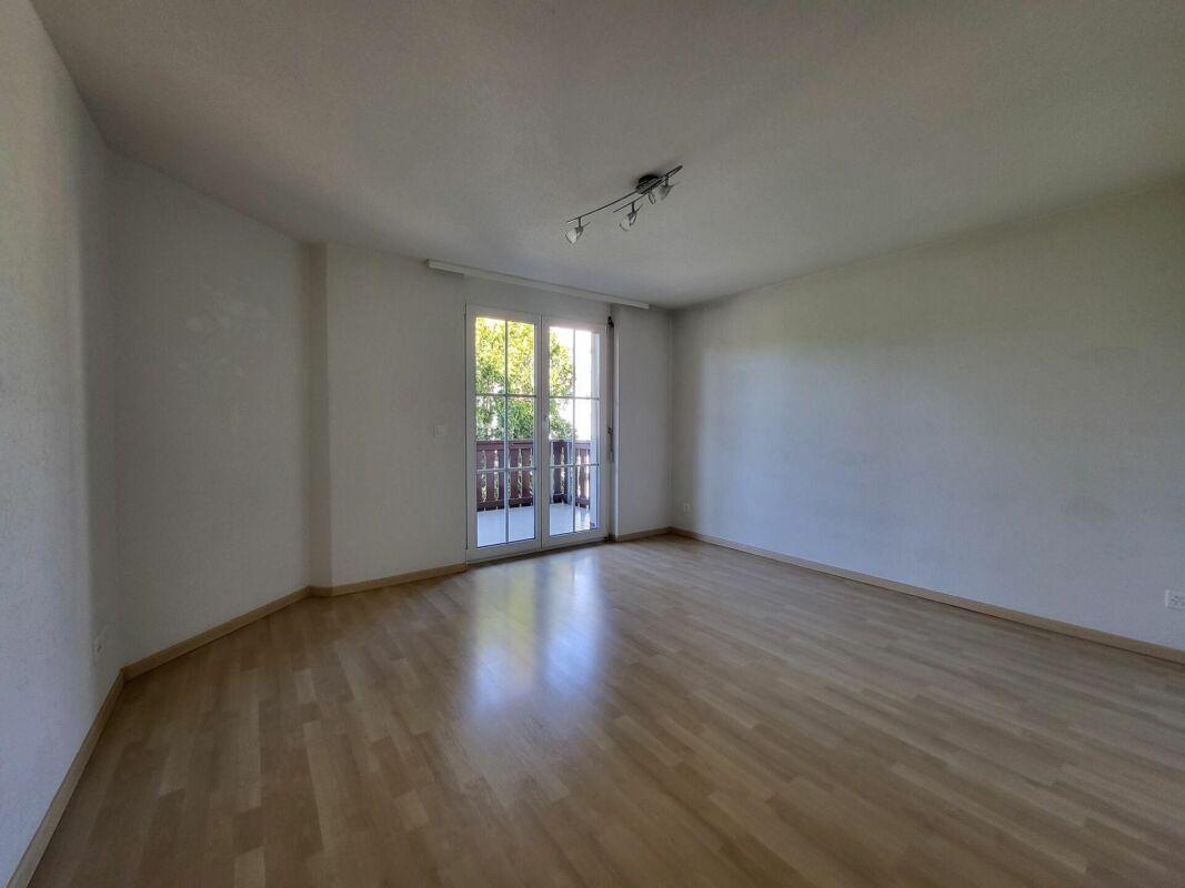 Leerer Wohnraum mit Balkonzugang