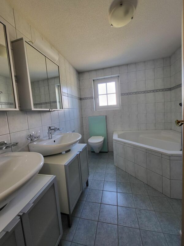 Badezimmer mit Wanne und Doppelwaschbecken