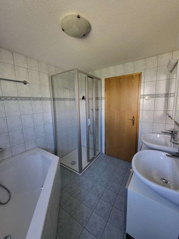 Badezimmer mit Dusche und Doppelwaschbecken