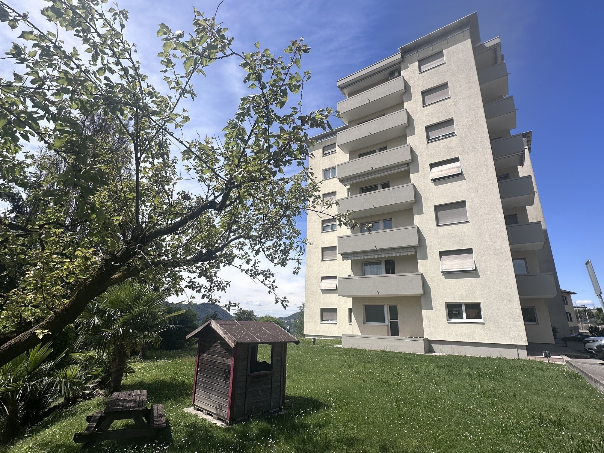 Mehrfamilienhaus mit Garten und Bäumen