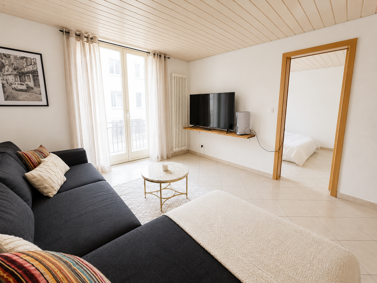 Helles Wohnzimmer mit Durchgang zum Schlafzimmer
