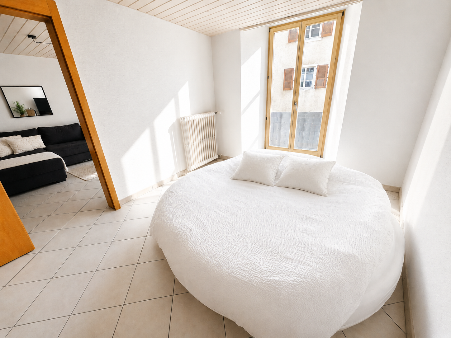 Helles Schlafzimmer mit Bett und Balkonfenster