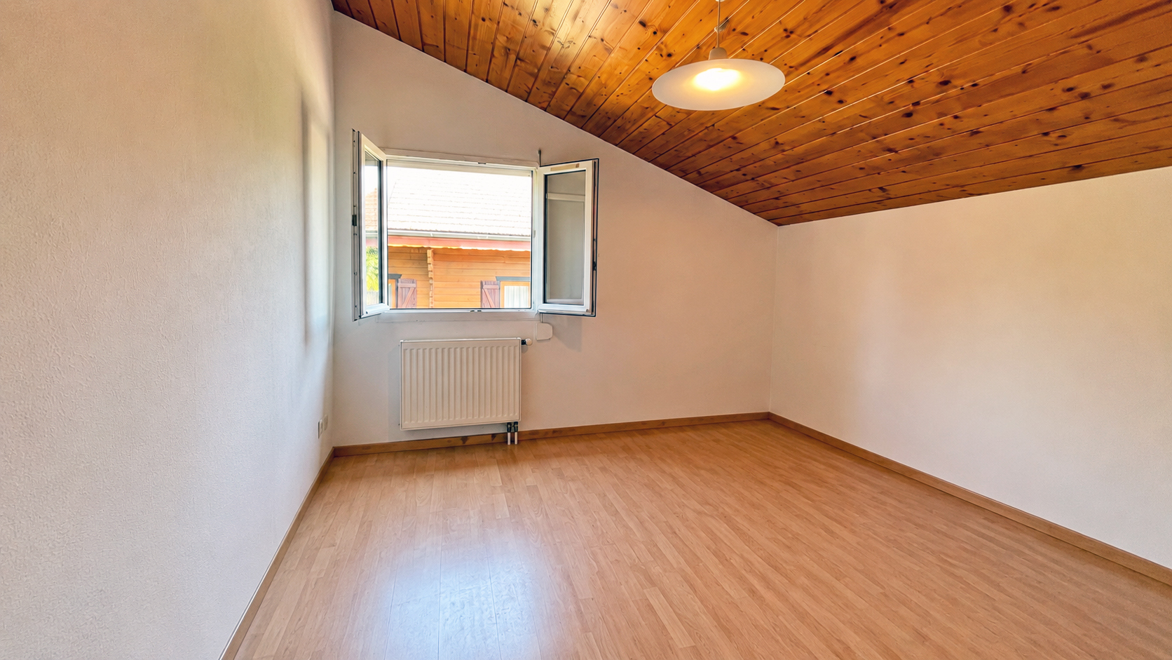 Leerer Dachraum mit Holzdecke und Fenster