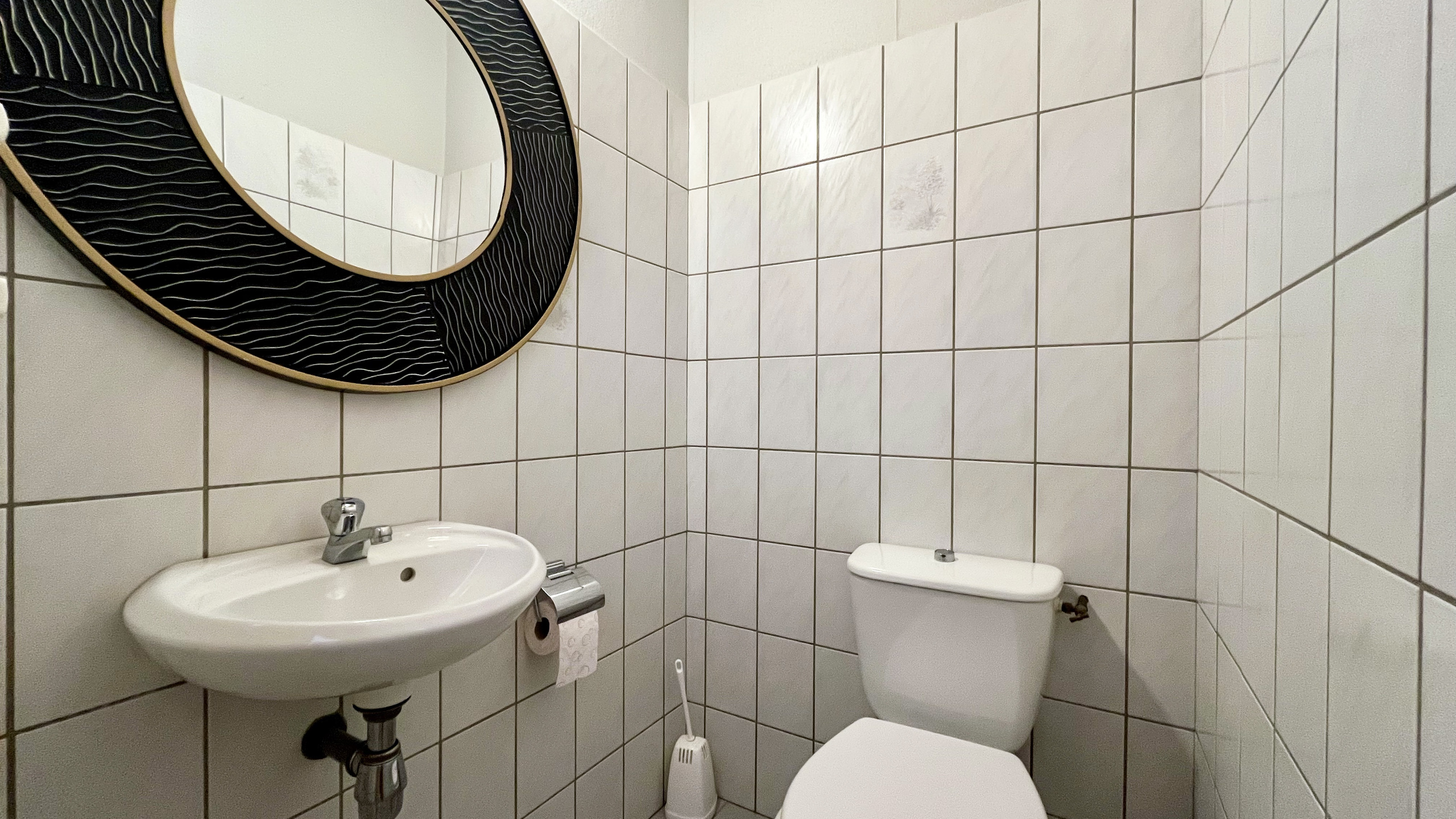 Gäste-WC mit Wand-WC und Spiegel
