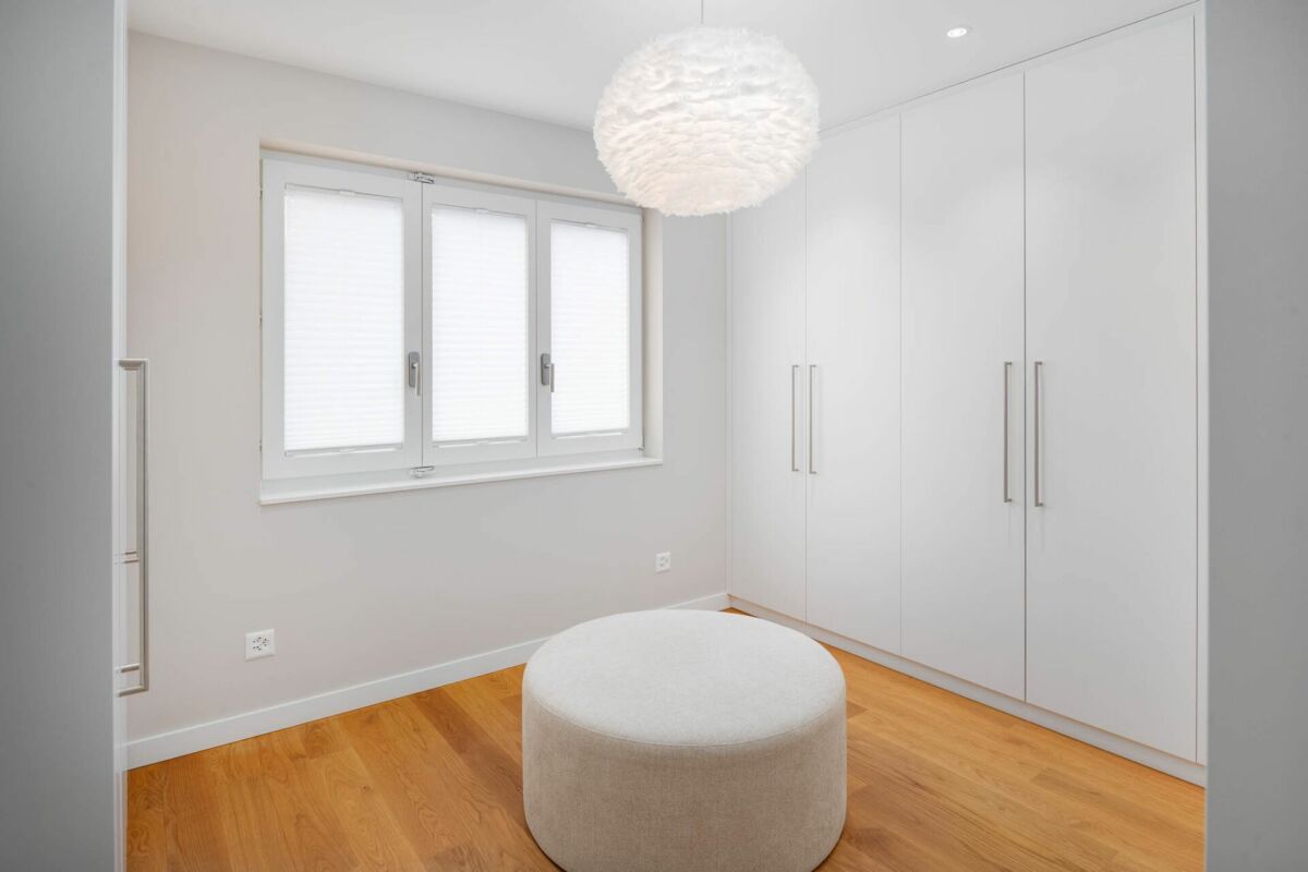 Helles Schlafzimmer mit Einbauschrank und Hocker